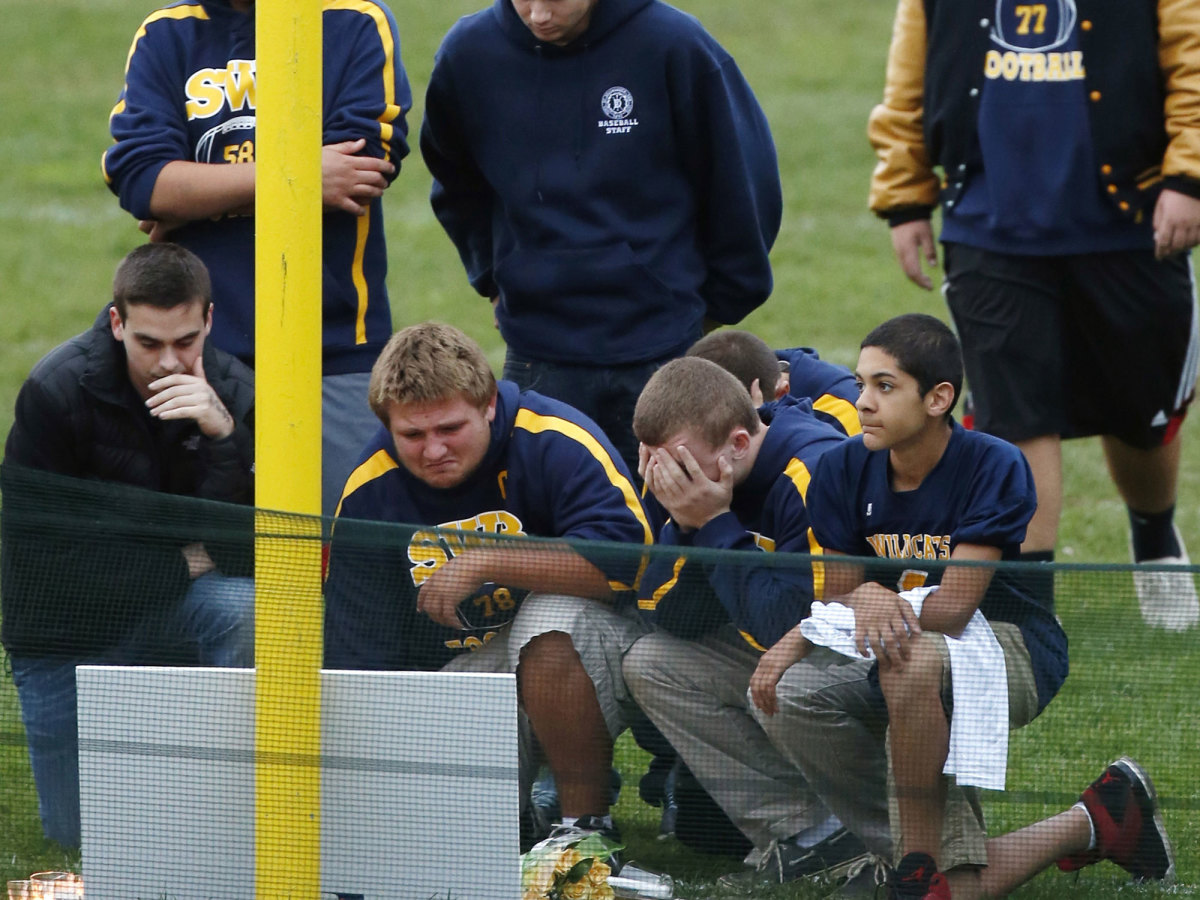 Shoreham-Wading River players gathered at a makeshift memorial for Tom Cutinella on the high school's football field.